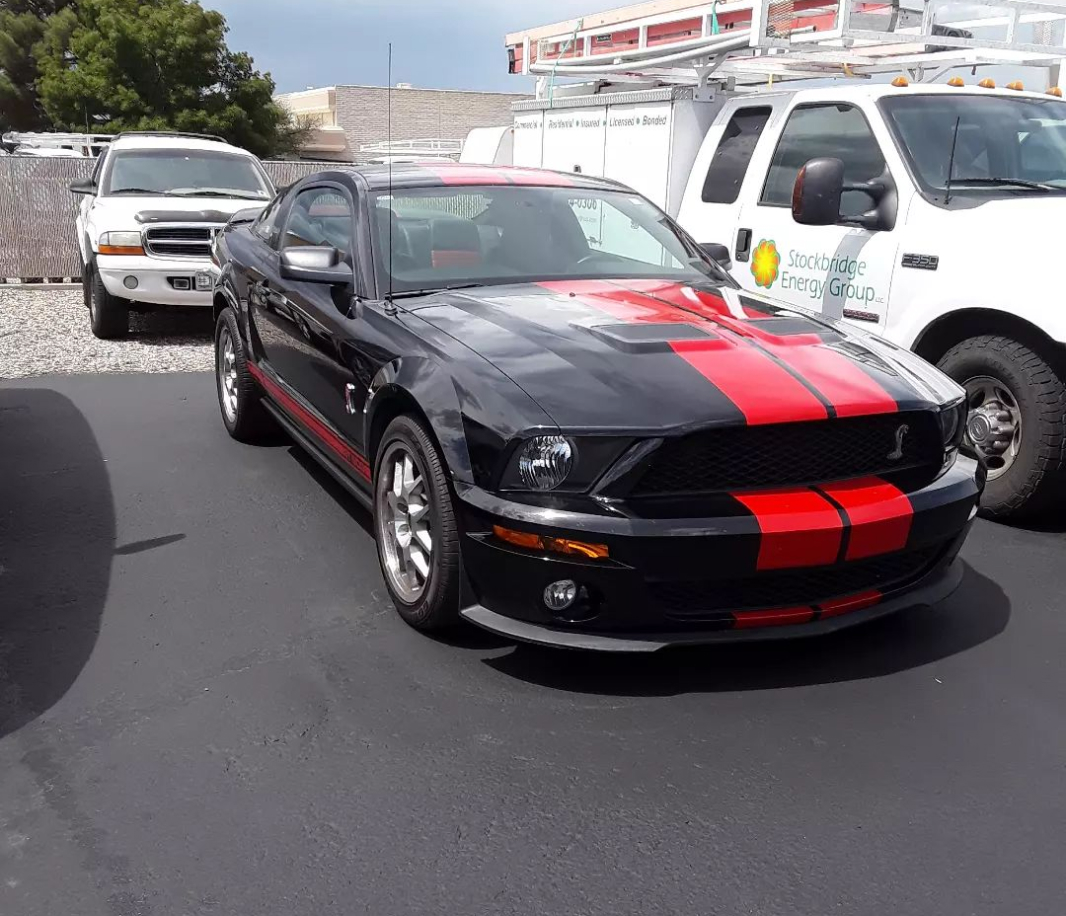 A black and red car is parked in the street