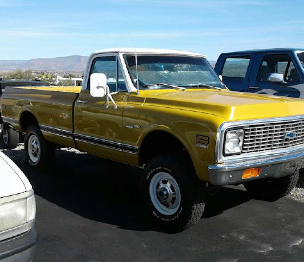 A yellow truck parked in the parking lot.